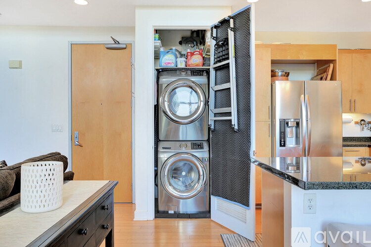 A modern kitchen with a washing machine and dryer built into the cabinetry.