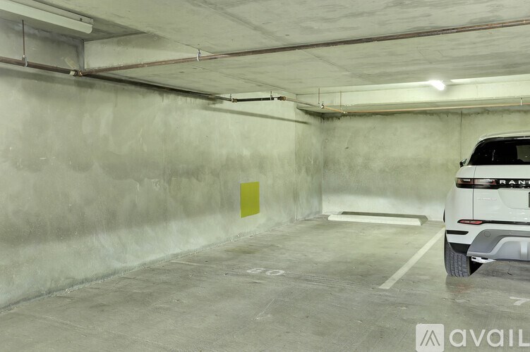 A white car is parked in a concrete garage.