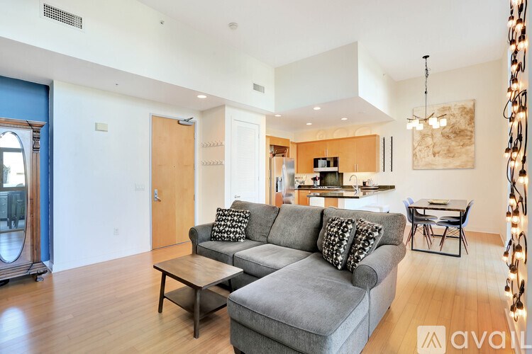 A living room with a grey couch and a wooden coffee table.