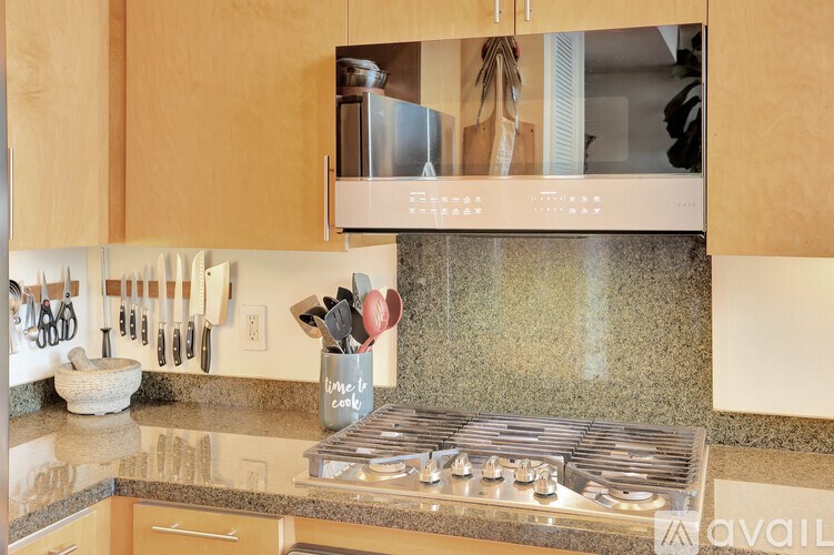 A kitchen with a stove top oven and a knife block.
