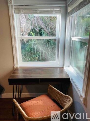 A window with a table and a chair in front of it.