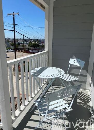 A small table and two chairs are on a porch.