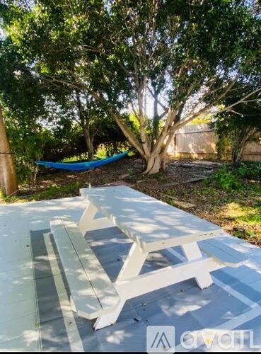 A picnic table is set up in a shaded area with trees around.