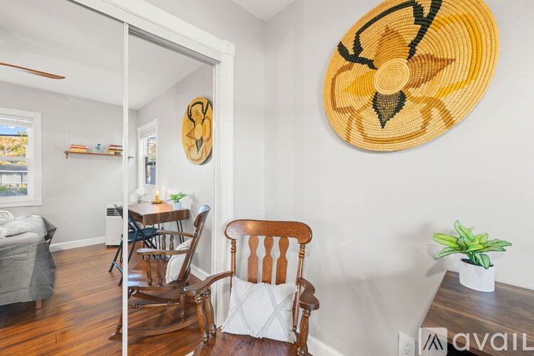 A room with a wooden chair and a woven wall hanging.