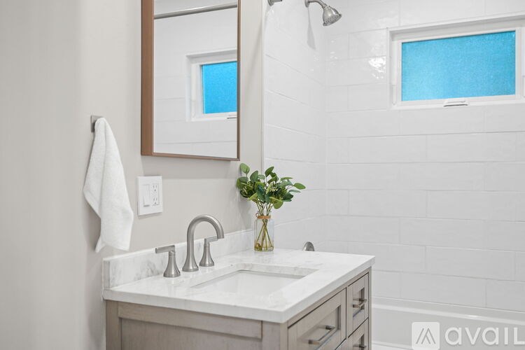 A bathroom with a white sink and a mirror above it.