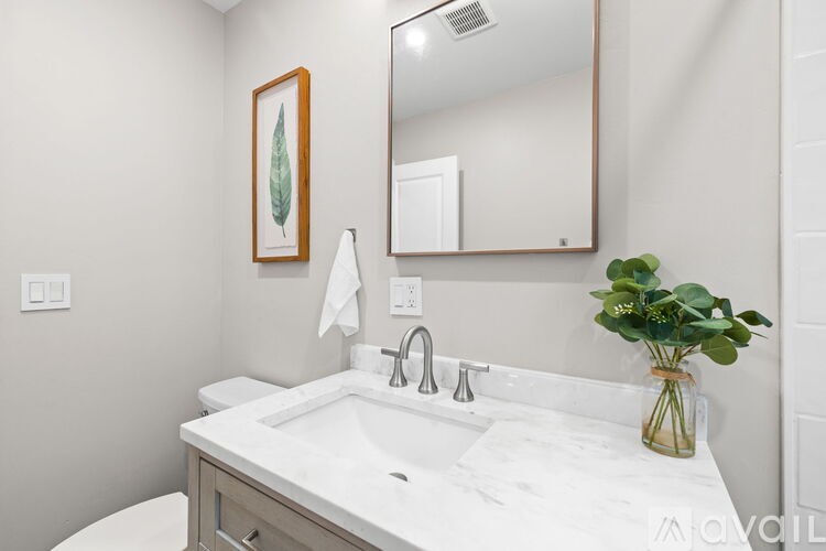 A bathroom with a white sink and a mirror above it.