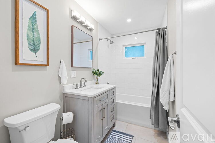 A bathroom with a white tub, sink, and toiletries.
