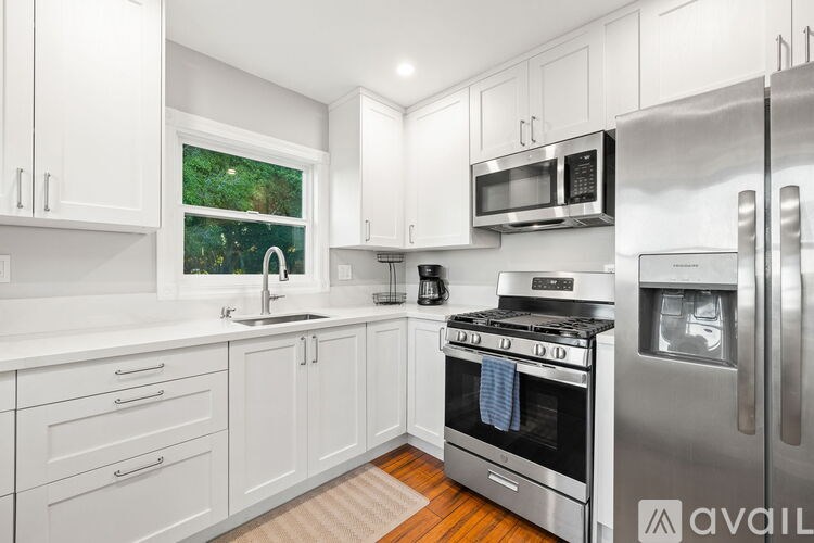A kitchen with white cabinets and a refrigerator.