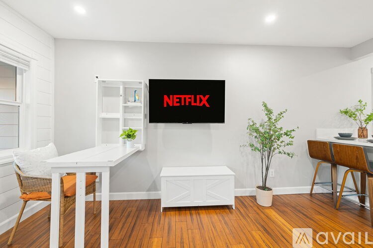 A living room with a grey couch, a wooden table, and a rug.