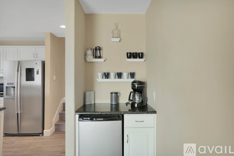 A kitchen with a black countertop and white cabinets.