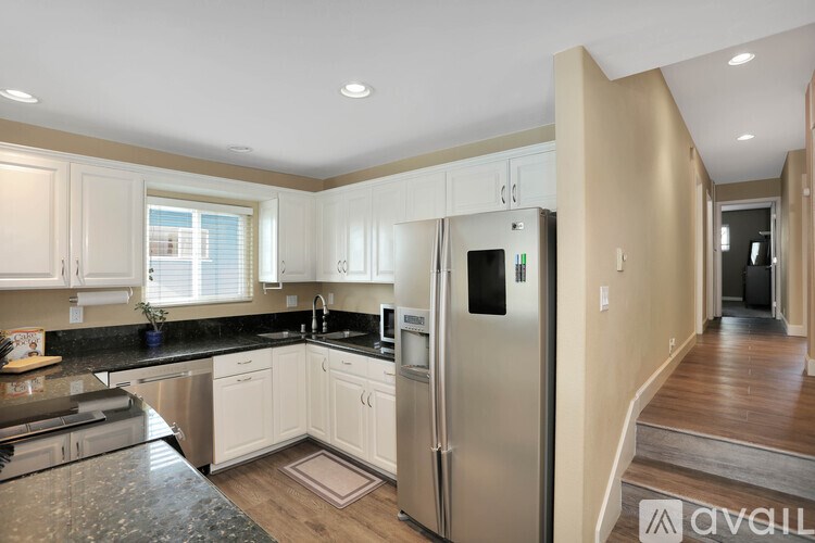 A kitchen with a granite counter top and stainless steel appliances.