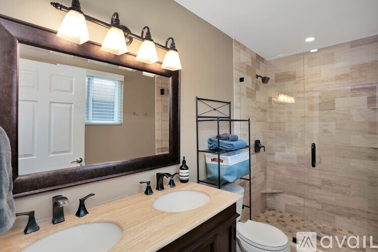 A bathroom with a wooden vanity and a large mirror.
