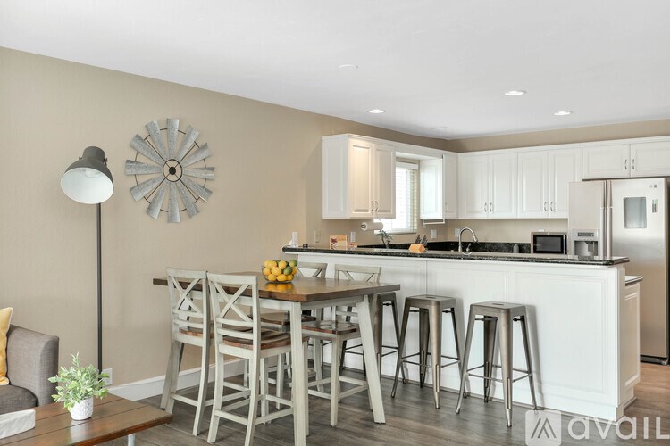 A kitchen with a bar stool and a table with chairs.