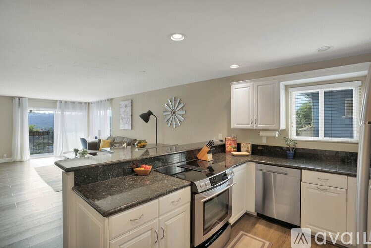 A kitchen with a black countertop and stainless steel appliances.