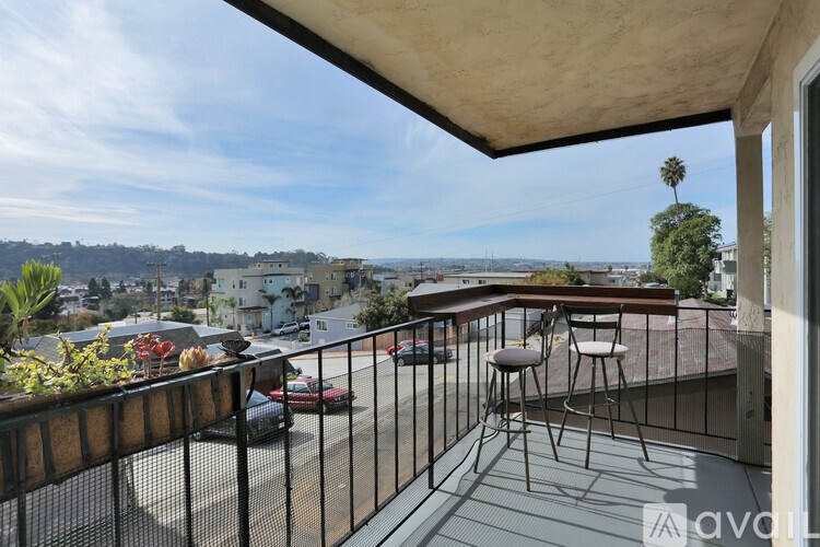 A balcony with a table and chairs overlooking a street.