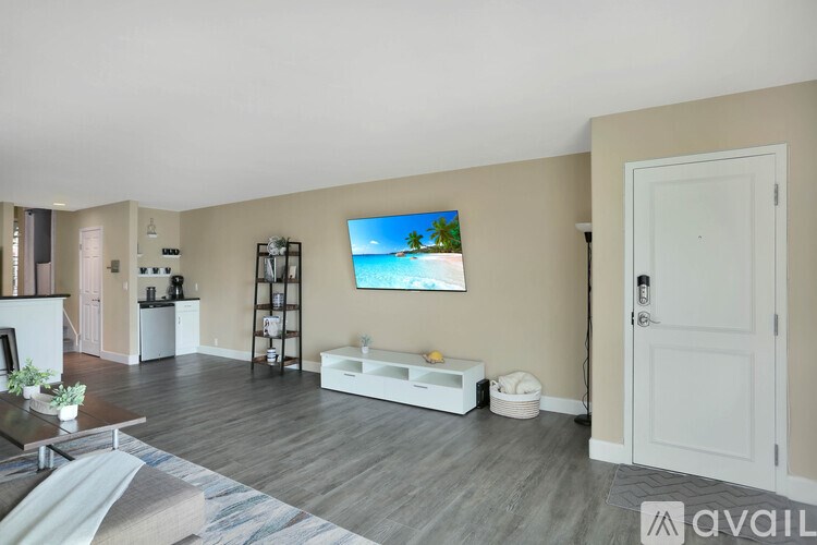 A living room with a flat screen TV mounted on the wall.