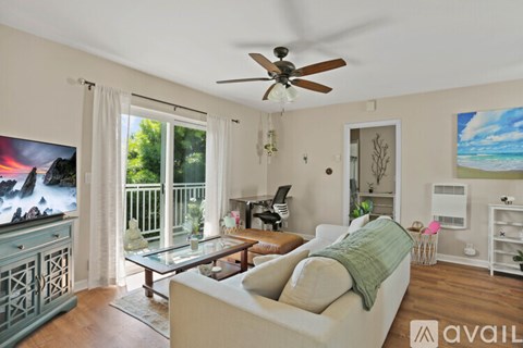 A living room with a white couch and a ceiling fan.