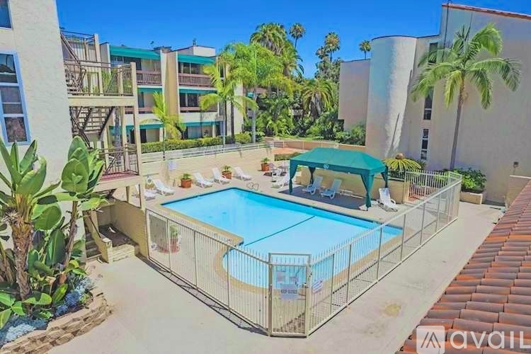 A pool surrounded by a fence and a green canopy.