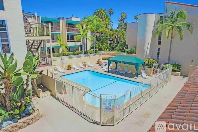 A pool surrounded by a fence and a green canopy.