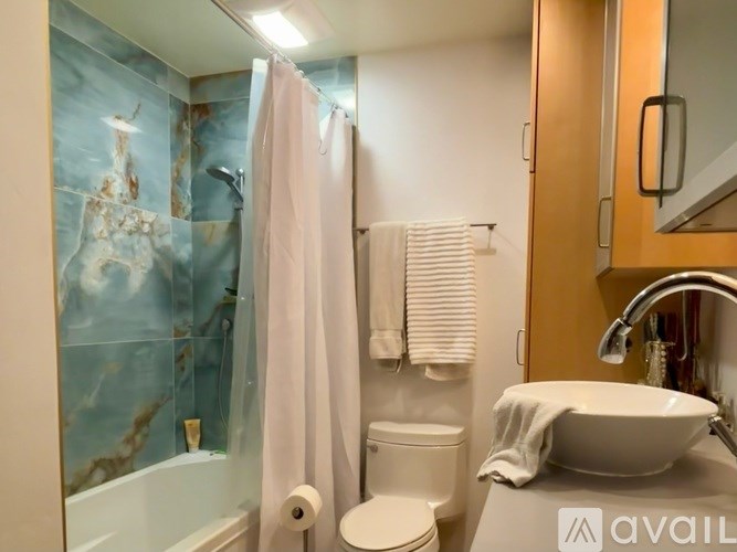 A bathroom with a white toilet, a white sink, and a shower with a glass door.