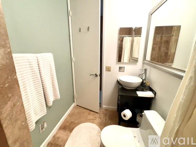 A bathroom with a toilet, sink, and mirror.