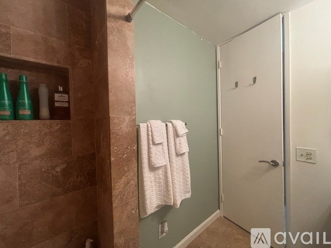 A bathroom with a towel hanging on the door.