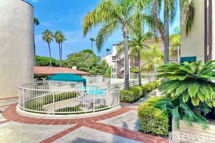 A pool surrounded by a fence and palm trees.