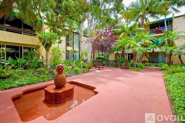 A pineapple statue sits on a pedestal in the middle of a courtyard.