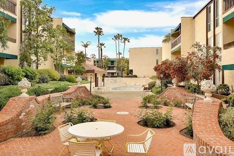 A courtyard with a table and chairs surrounded by buildings.