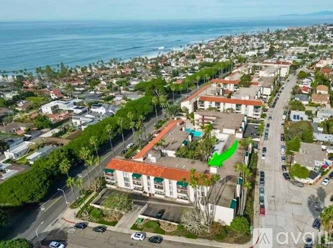 A green arrow points to a building in the middle of a street.