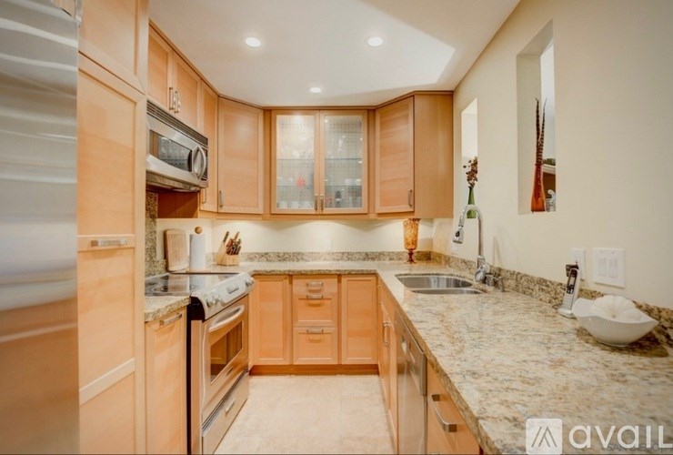A kitchen with wooden cabinets and granite countertops.