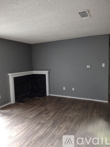 A room with a fireplace and wooden flooring.