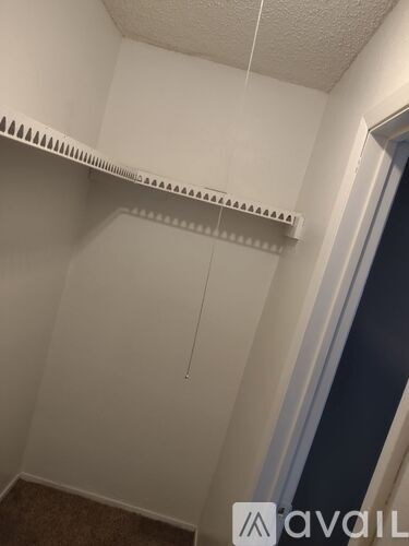 A white shelf with a string hanging from it.