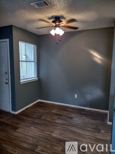 A room with a ceiling fan and a window.