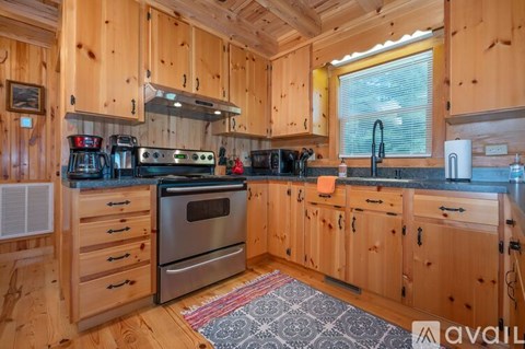 A kitchen with wooden cabinets and a stove top oven.