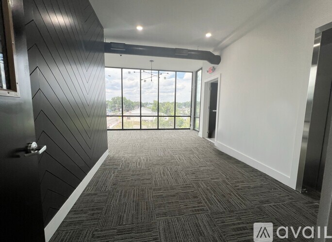 A room with a carpeted floor and a large window overlooking the outdoors.