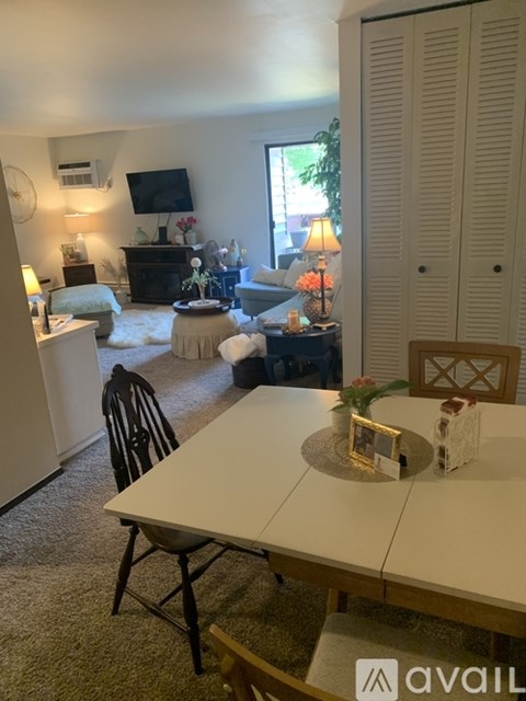 A living room with a white dining table and chairs.