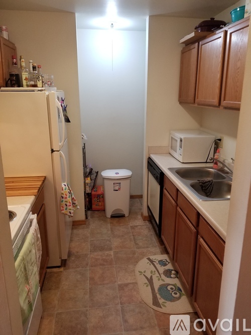 A kitchen with brown cabinets and a white refrigerator.