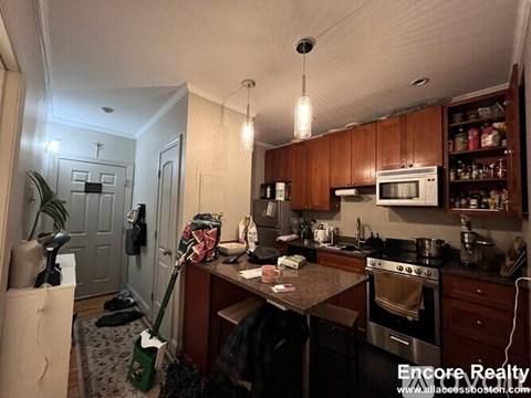 A kitchen with wooden cabinets and a black stove top.