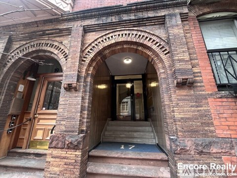 A brick building with a wooden door and a window.