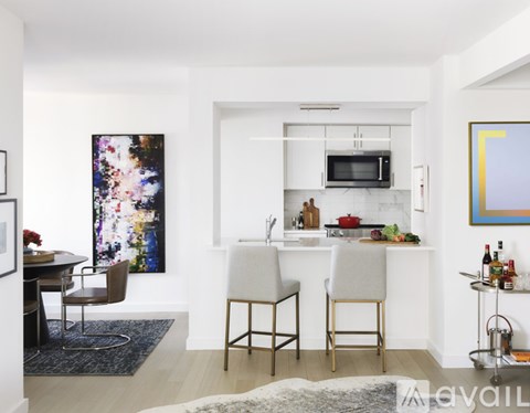 A modern kitchen with white cabinets and a bar area.