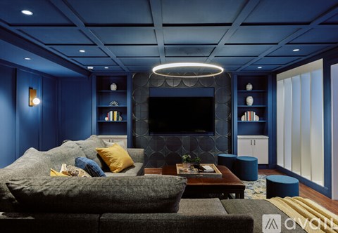 A modern living room with a grey sofa and a television.