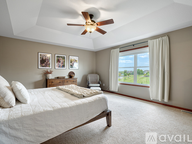 A bedroom with a large bed and a ceiling fan.