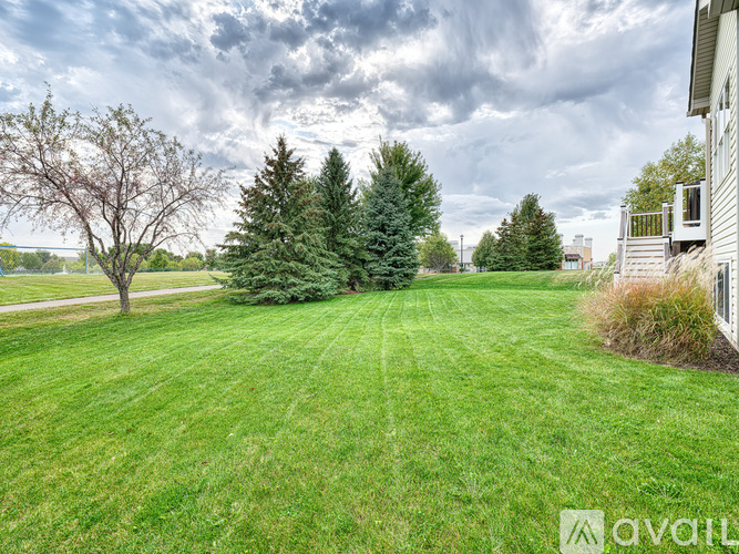 A large, well-maintained lawn with trees and a house in the background.