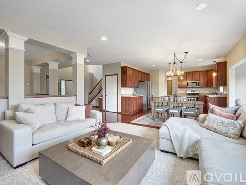 A living room with a white couch and a coffee table in the center.