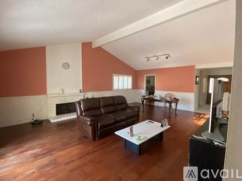 A living room with a brown leather couch and a white coffee table.