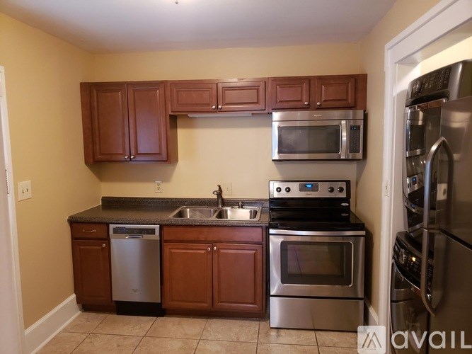 A kitchen with brown cabinets and stainless steel appliances.
