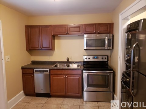 A kitchen with brown cabinets and stainless steel appliances.