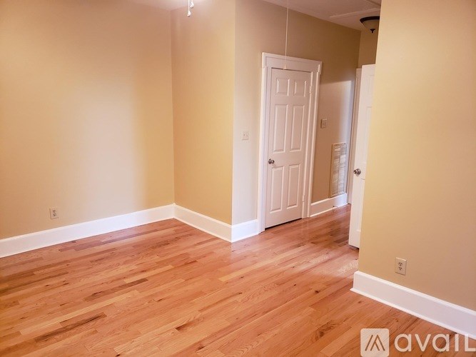 A room with wooden floors and a white door.