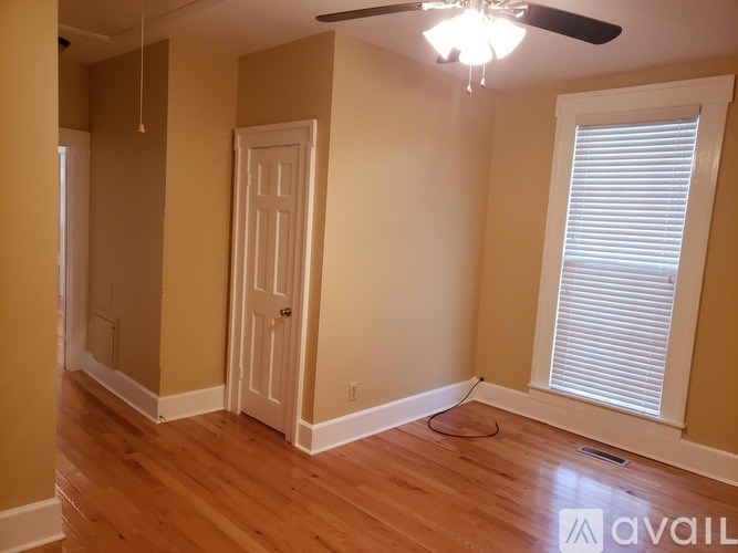 A room with a ceiling fan and a door.